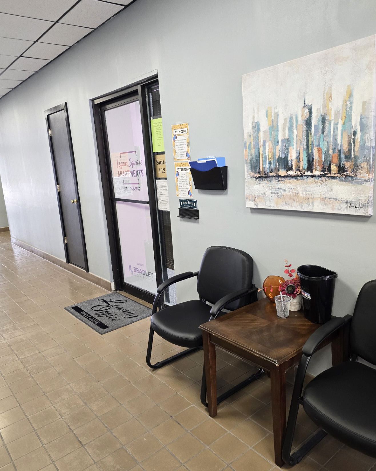 A waiting area with chairs and a painting on the wall.